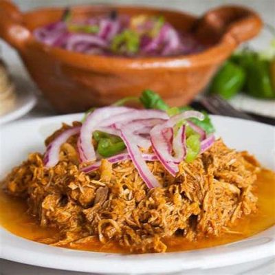  Cochinita Pibil: ซาบซ่าด้วยรสชาติเผ็ดร้อนและความละมุนของเนื้อหมูที่ตุ๋นอย่างช้าๆ!